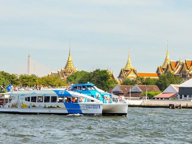 Ein Chao-Phraya-Touristenboot fährt am Großen Palast in Bangkok vorbei.