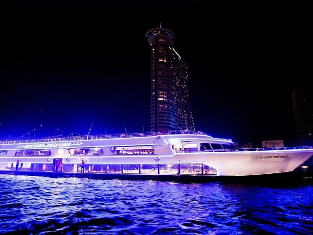 Ein hellweißes Dinner-Cruise-Boot auf dem Fluss bei Nacht.
