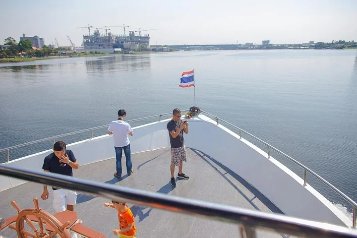 Passagers prenant des photos à l'avant d'un bateau d'excursion pendant la journée.