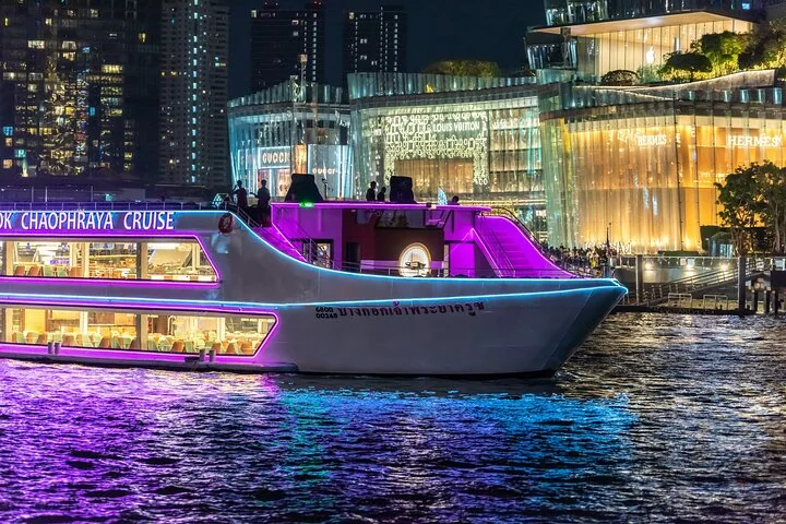 Nahaufnahme eines leuchtenden violetten Dinner-Kreuzfahrtschiffs in der Nähe eines Einkaufszentrums.